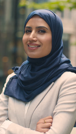 Vertical-Video-Portrait-Of-Muslim-Businesswoman-Outdoors-Standing-In-Front-Of-City-Offices-1